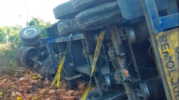 El tráiler terminó volcado y su carga esparcida por la vía.