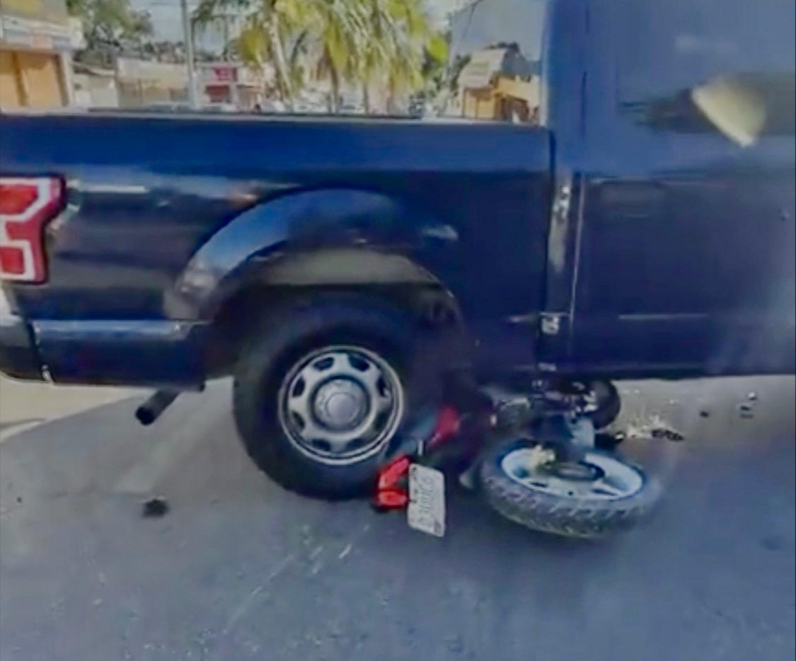 La motocicleta quedó debajo de la camioneta tras el incidente.