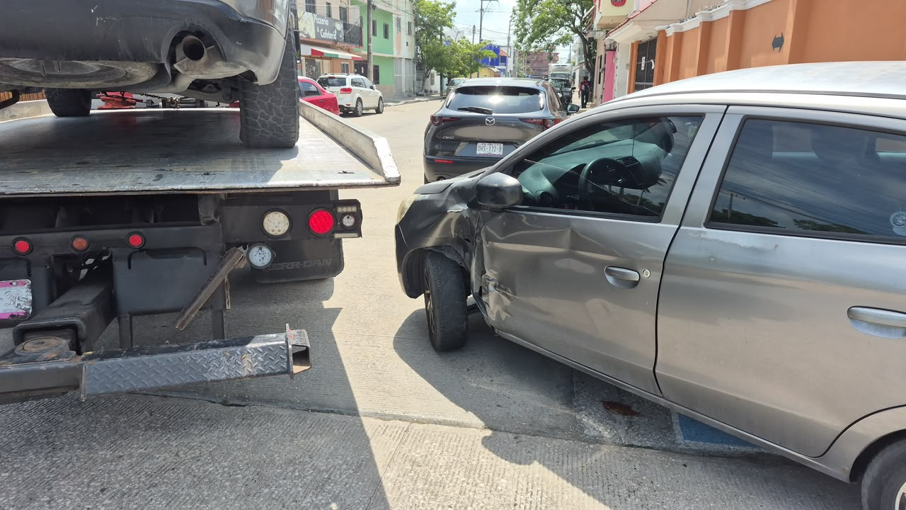 La parte trasera de la grúa golpeó un Mitsubishi Mirage gris.