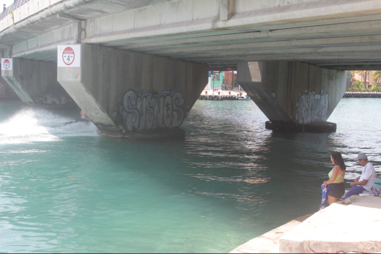 Usuarios cruzan nadando  o permanecen  flotando