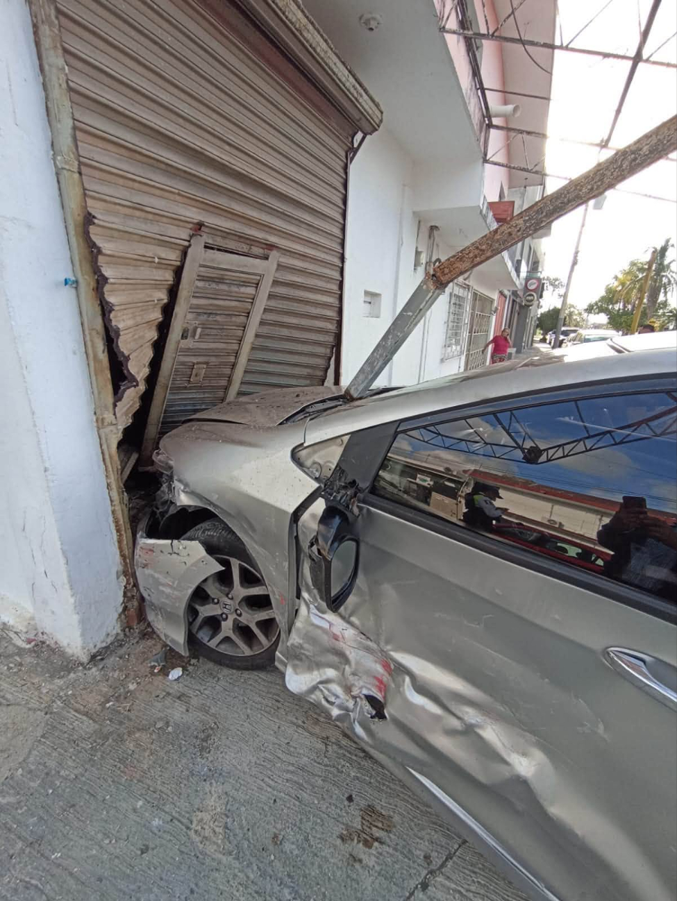 El Honda Civic terminó impactado contra la cortina metálica de un local
