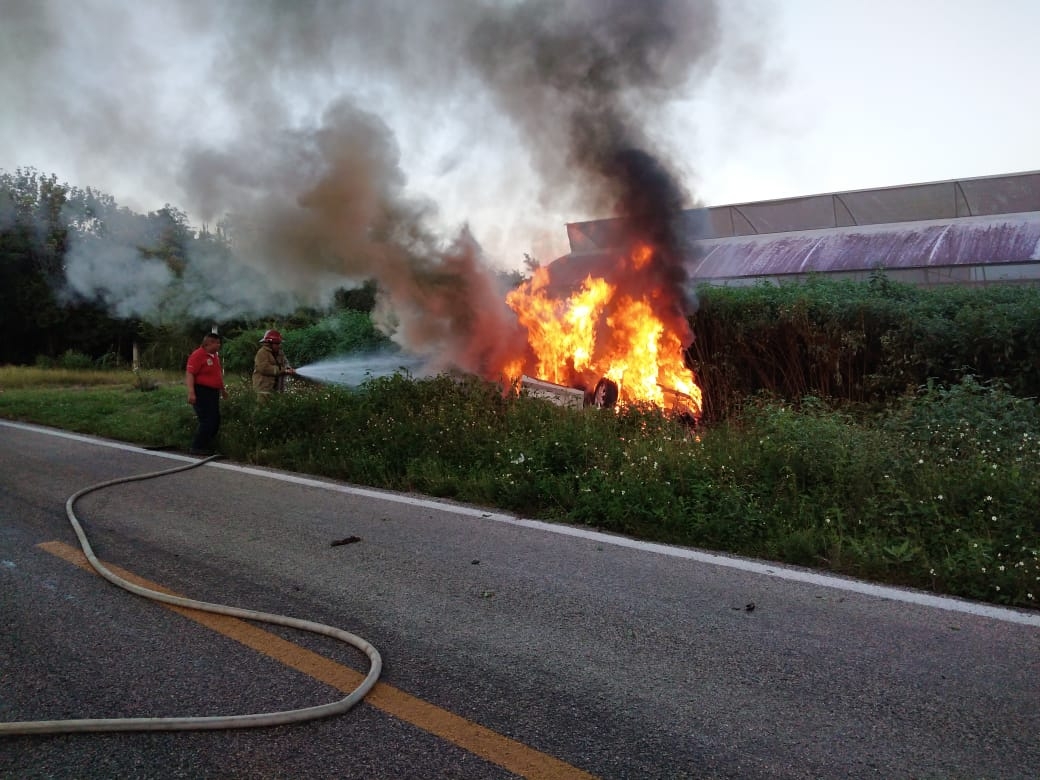 Al lugar arribaron bomberos para proceder a apagar la unidad en llamas Al lugar arribaron bomberos para proceder a apagar la unidad en llamas