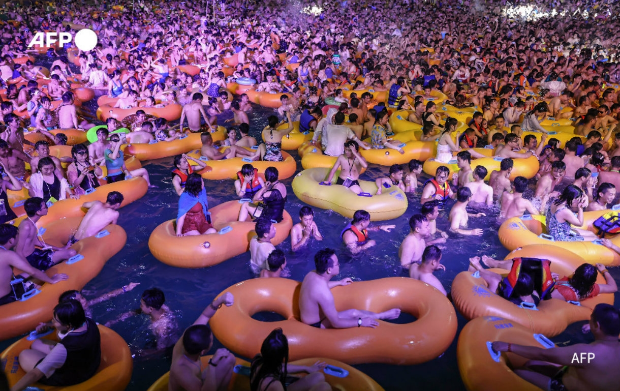 La gente disfruta de un show mientras se refresca en una piscina en Wuhan (AFP)