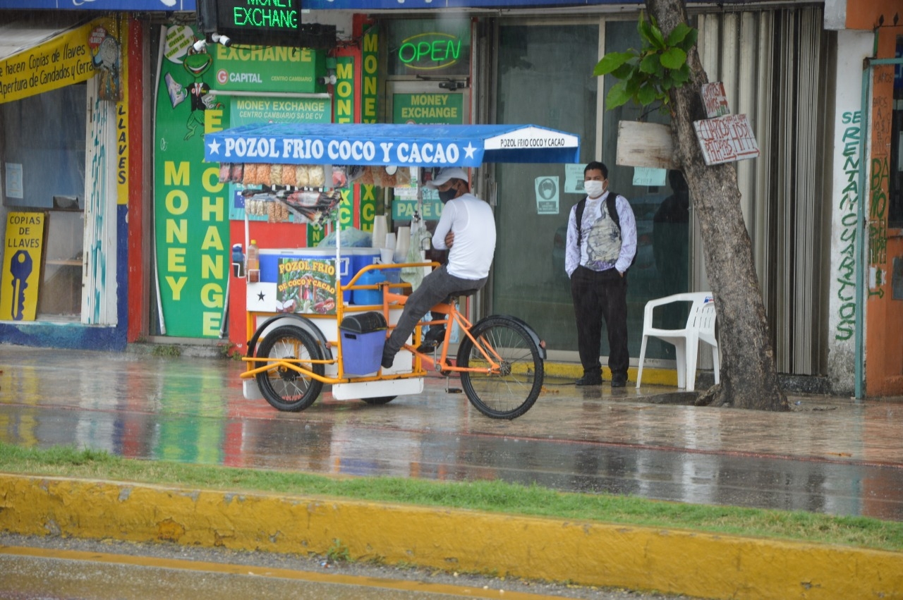 Chamarras, impermeables y paraguas, se veían por las principales calles turísticas y del centro de Playa del Carmen