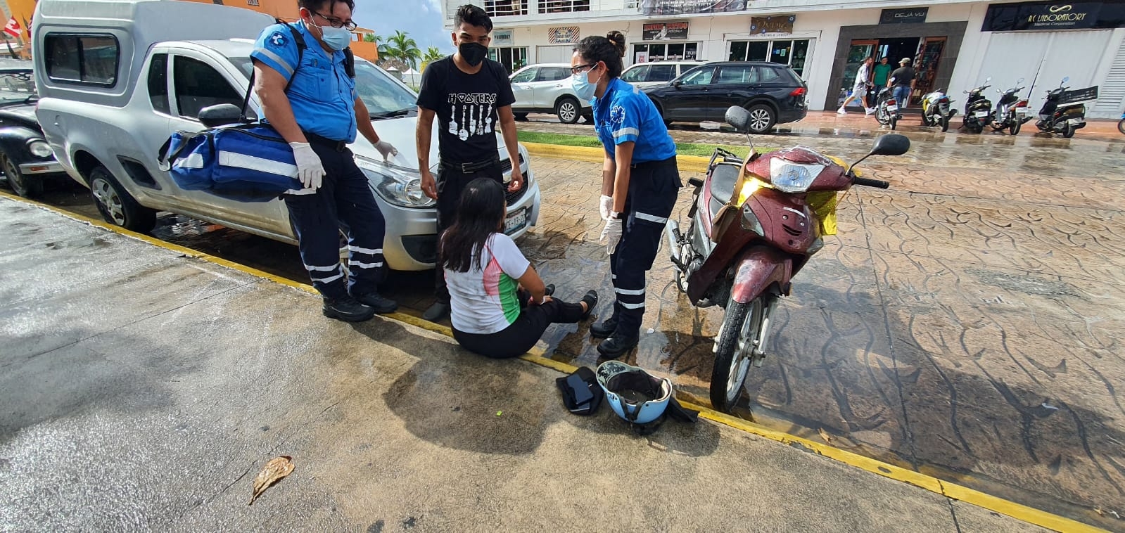 Motociclista derrapa sobre carretera mojada en avenida Rafael E. Melgar en Playa del Carmen