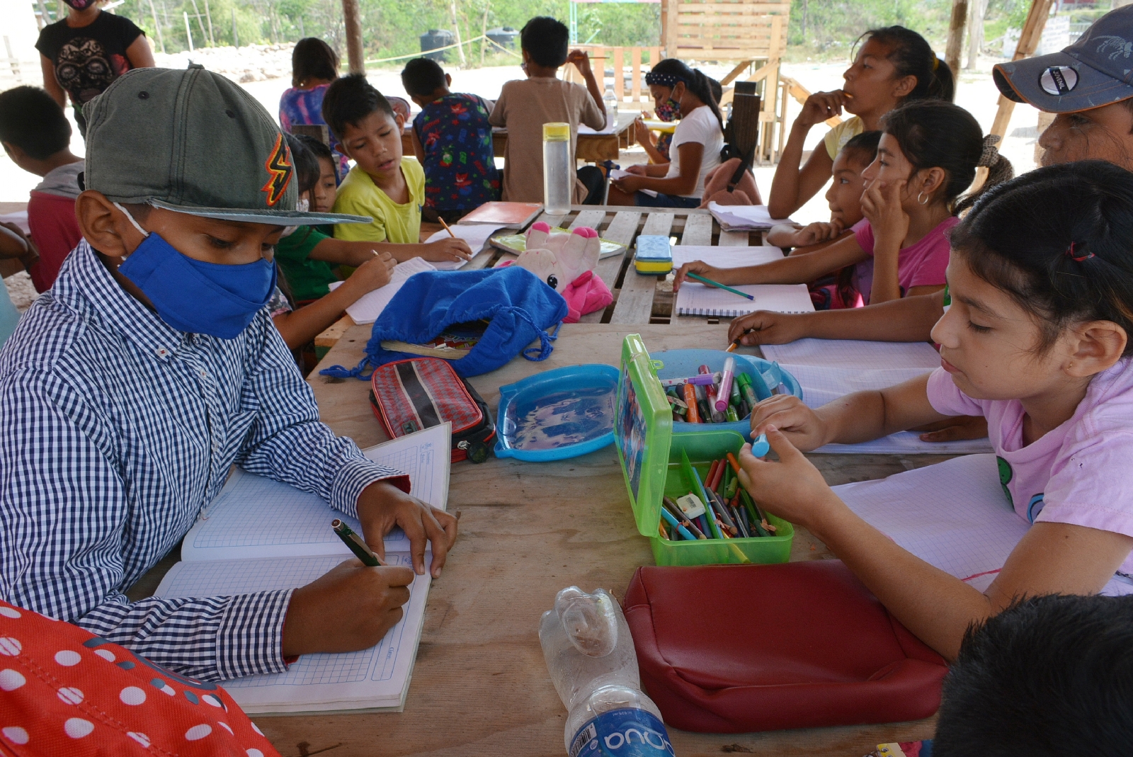 En un tinglado y con improvisado mobiliario escolar, las maestras realizan su labor