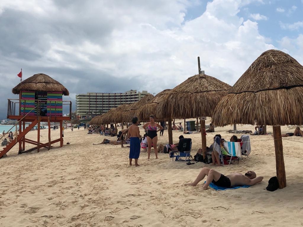 Turistas se recostaban en la arena para disfrutar las playas Turistas se recostaban en la arena para disfrutar las playas