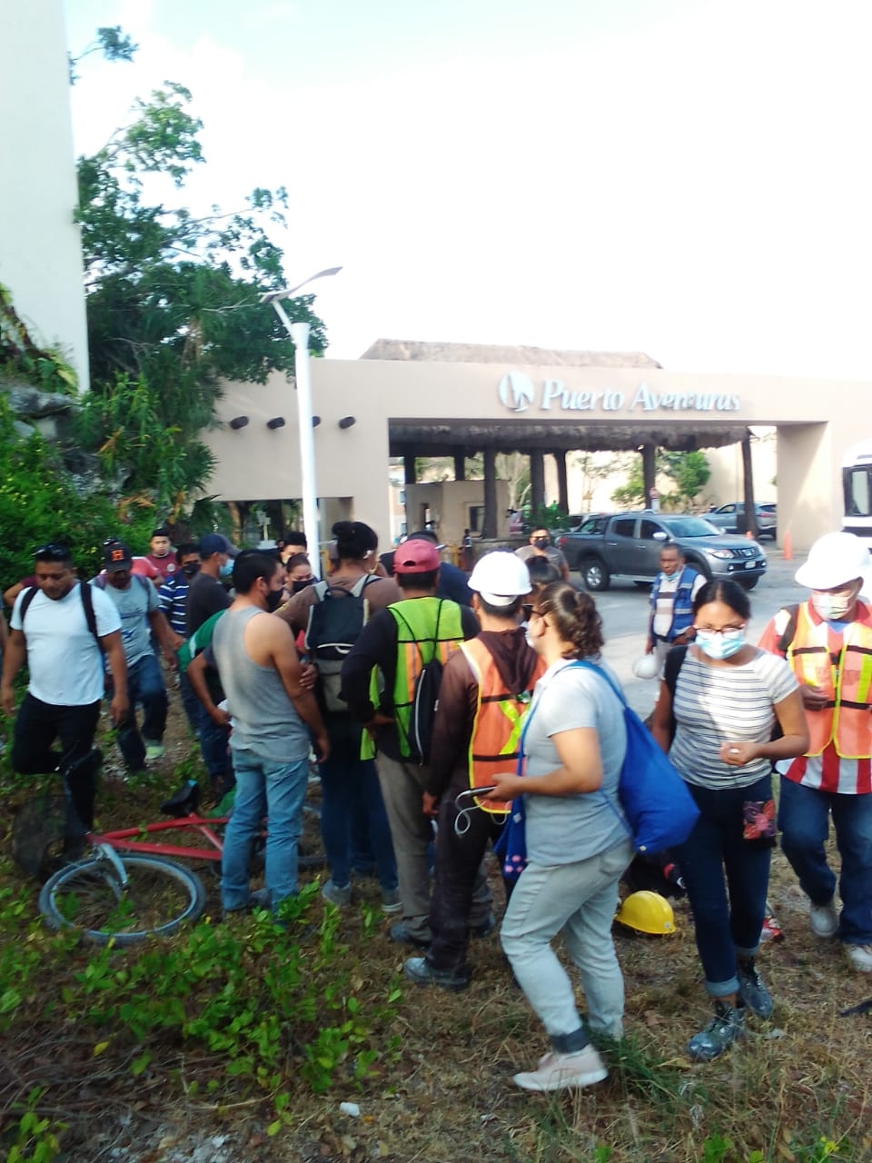 Lo trabajadores esperan en la entrada para ir a sus labores
