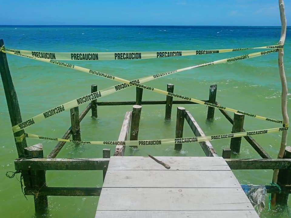 El muelle de Chelem está ubicado a la orilla de la playa con casas veraniegas El muelle de Chelem está ubicado a la orilla de la playa con casas veraniegas
