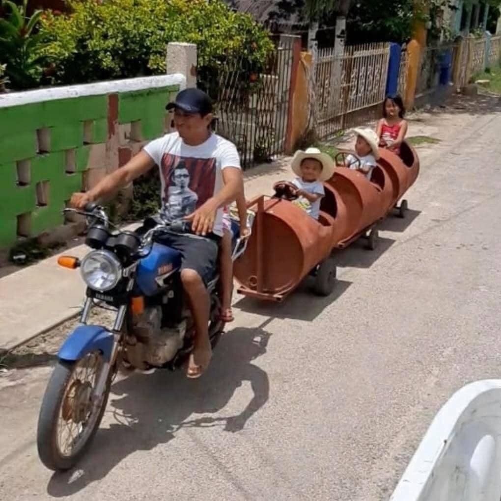 El papá jalaba el tren con una moto por las calles de Maní, Yucatán