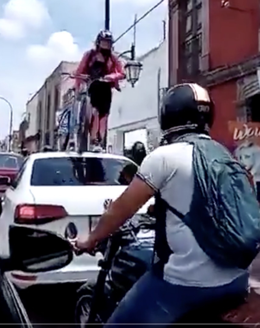 Este es el momento en que la ciclista pasa por encima de un auto estacionado en plena ciclovía