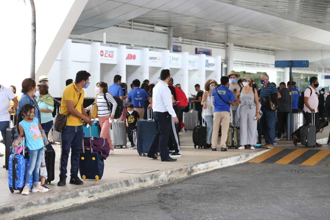 Afuera de las terminales del Aeropuerto Internacional de Cancún se observó aglomeración de personas, algunas sin cubrebocas