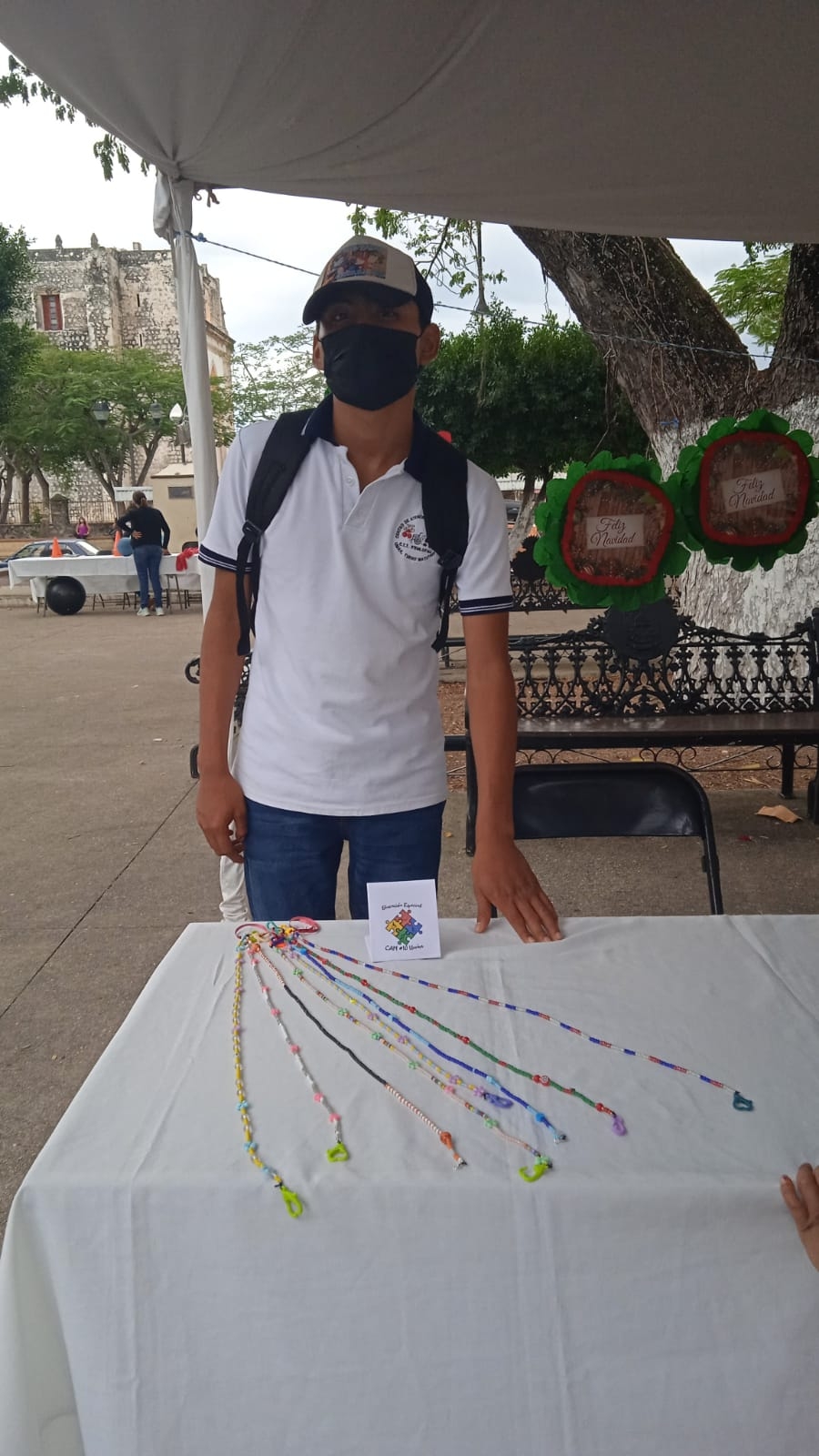 Osvaldo Cob realiza pulseras, porta cubrebocas y otras prendas de bisutería con colores llamativos, con ayuda de su mamá