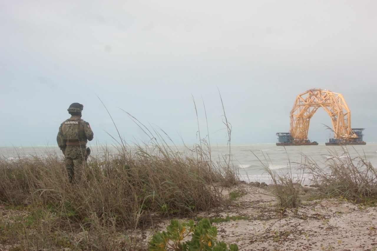 Un elemento de la Semar observa la estructura entre el mar picado