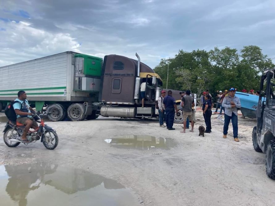 La llanta de un pesado tractocamión se hundió en una calle de arena húmeda La llanta de un pesado tractocamión se hundió en una calle de arena húmeda