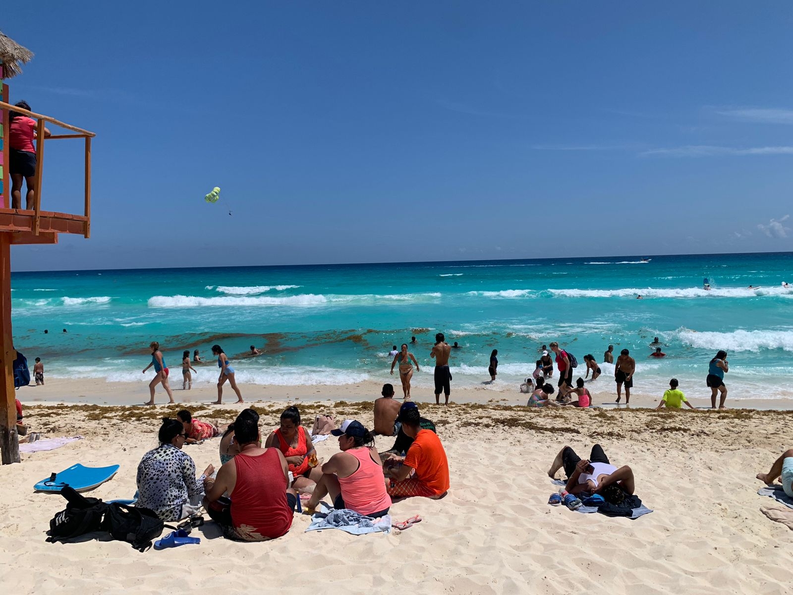 Familias enteras disfrutan del agua color turquesa de la playa