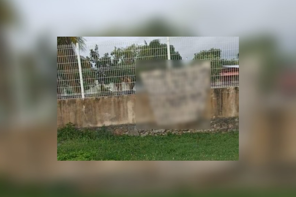 La manta color blanco apareció en la barda perimetral de la Secundaria de Calderitas, que posteriormente fue retirada por policías