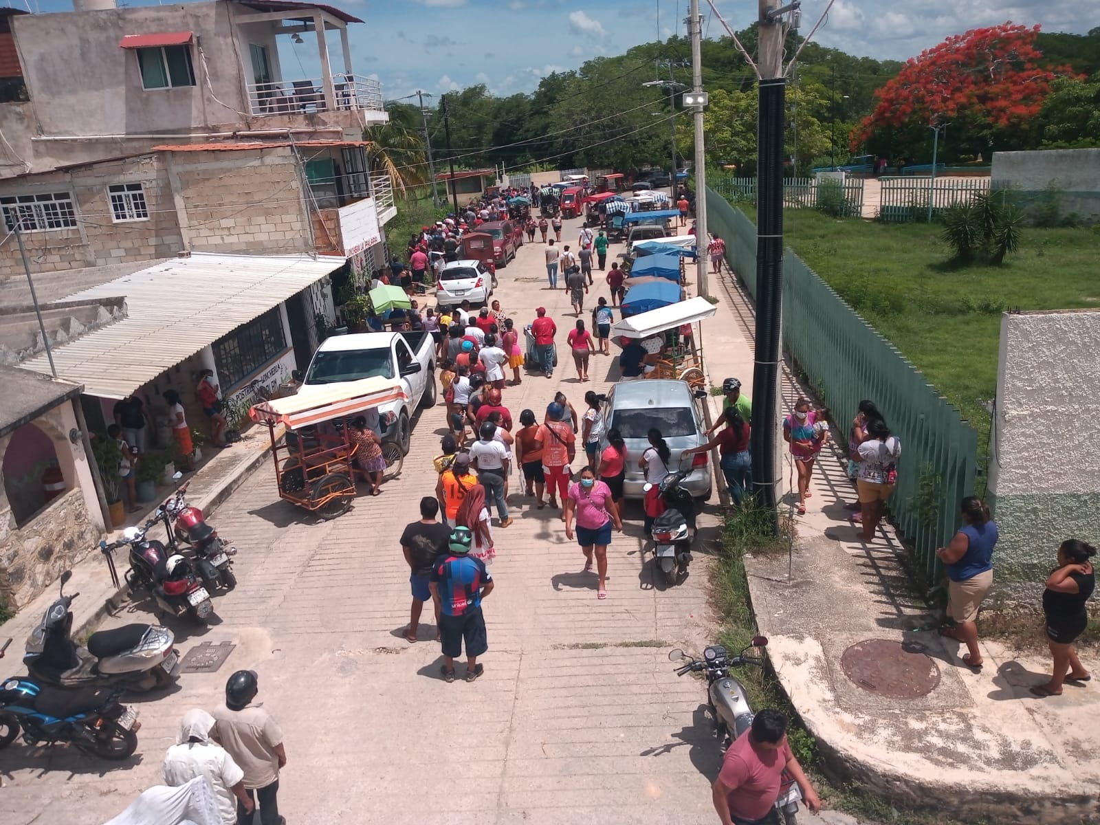 Una larga fila se forma afuera de la escuela normal de personas que fueron por su pedazo de carne robada