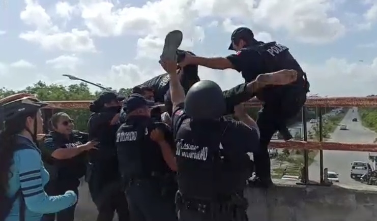 El hombre fue jalado por seis policías para evitar que se suicide desde el puente
