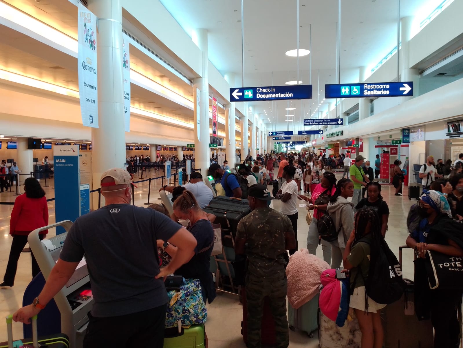 Algunos turistas descienden de sus vehículos de transporte para caminar y no perder sus vuelos en Cancún