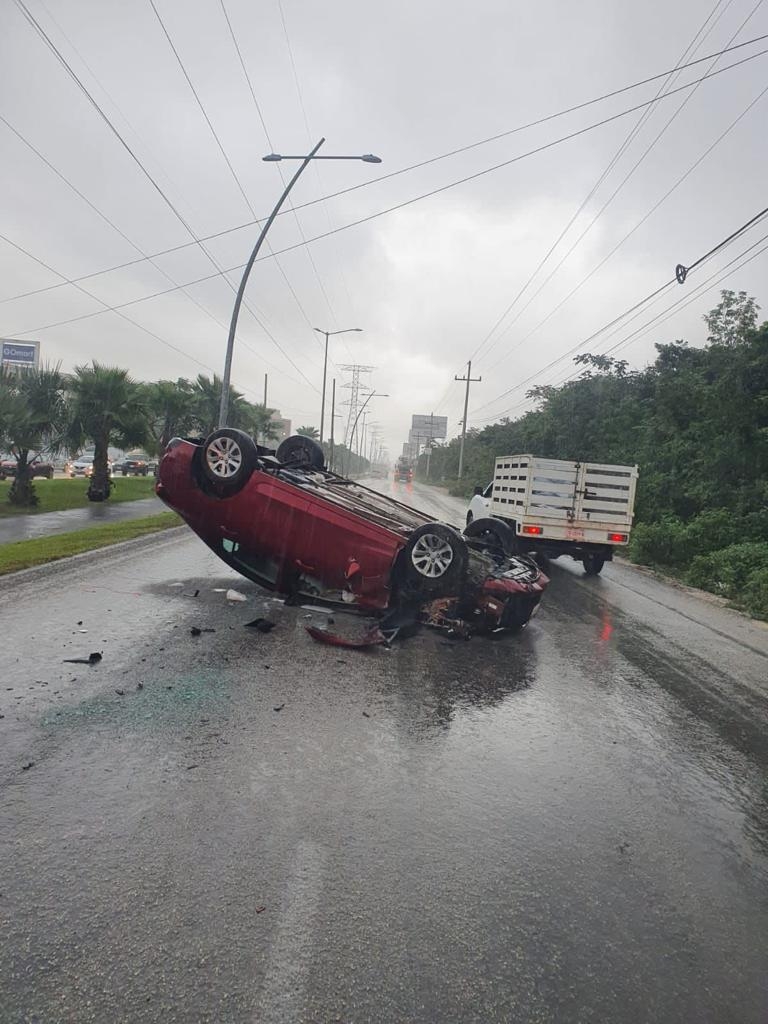 Automóvil se vuelca luego de perder el control por el pavimento mojado en Cancún