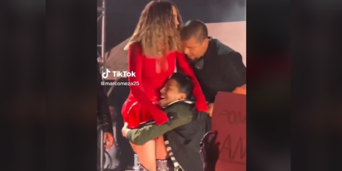 El fan logró burlar la seguridad para subir al escenario junto a Belinda. Foto: Especial