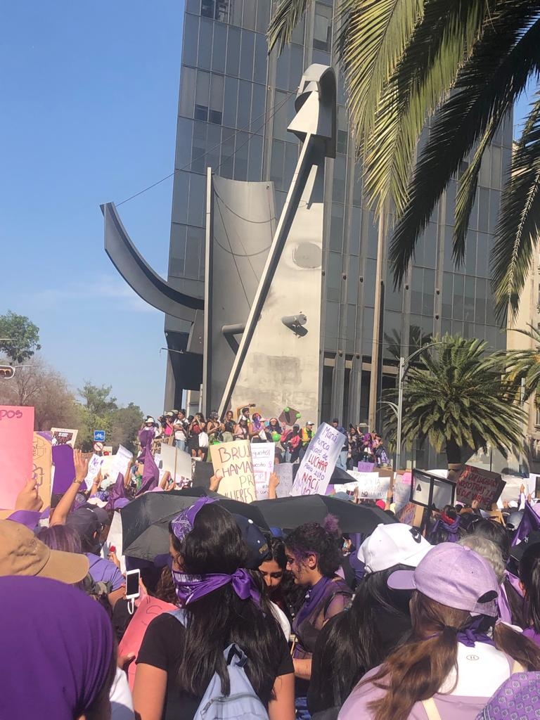 Mujeres reunidas con carteles y sus pañuelos morados