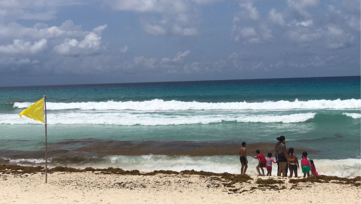 Turistas, tanto nacionales como internacionales, están en el arenal disfrutando de la brisa y el sol