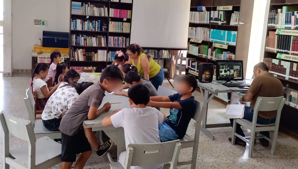 Las bibliotecarias están trabajando con los niños y niñas diversas actividades recreativas Las bibliotecarias están trabajando con los niños y niñas diversas actividades recreativas